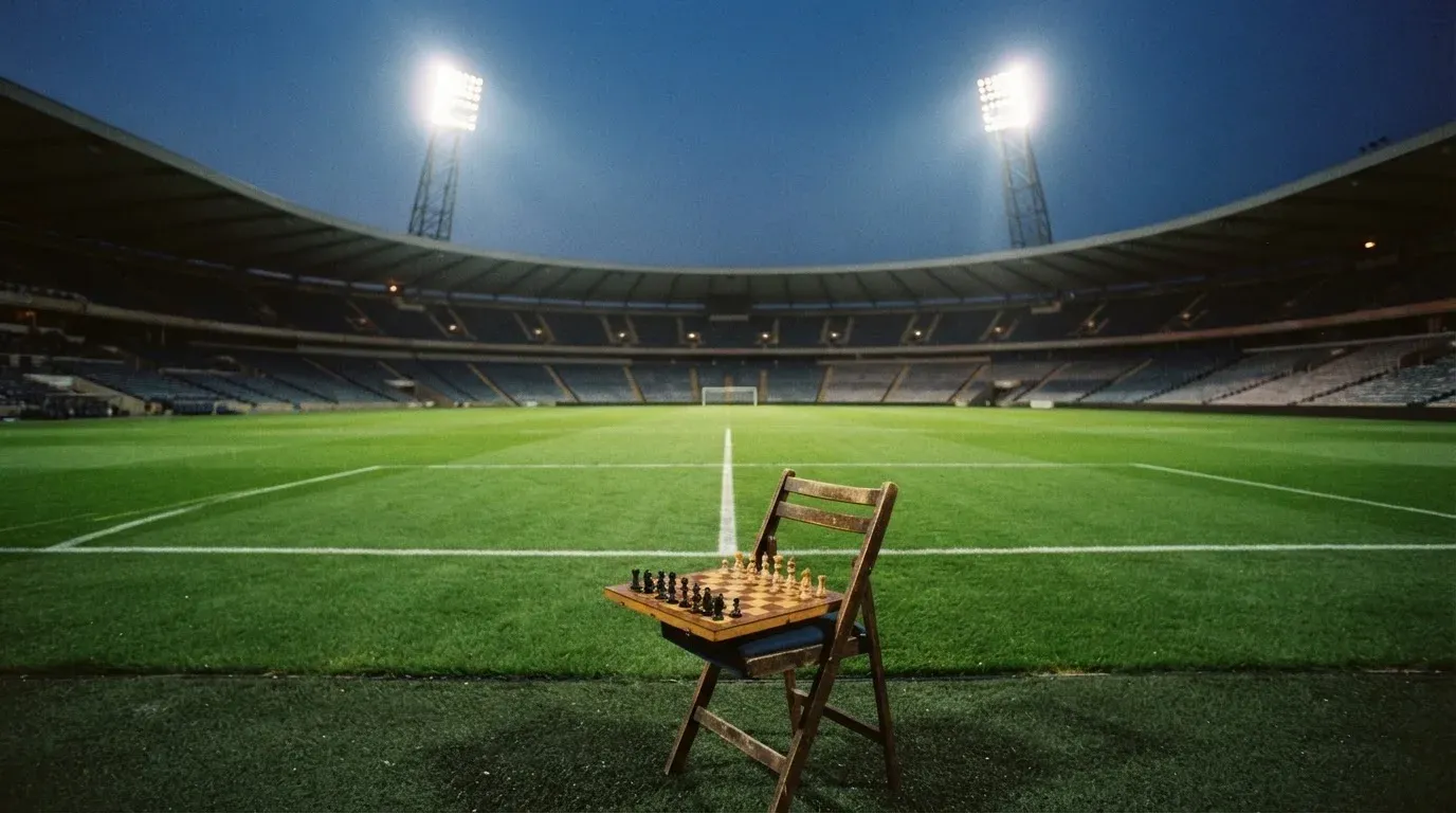 An empty football stadium with floodlight masts at dusk
