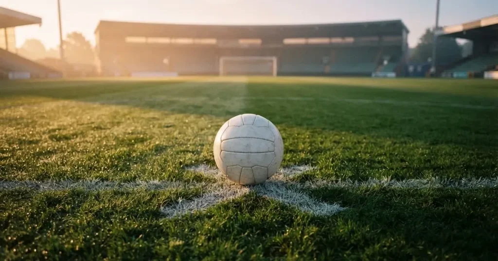 A ball on the centre spot of a grass pitch in morning light