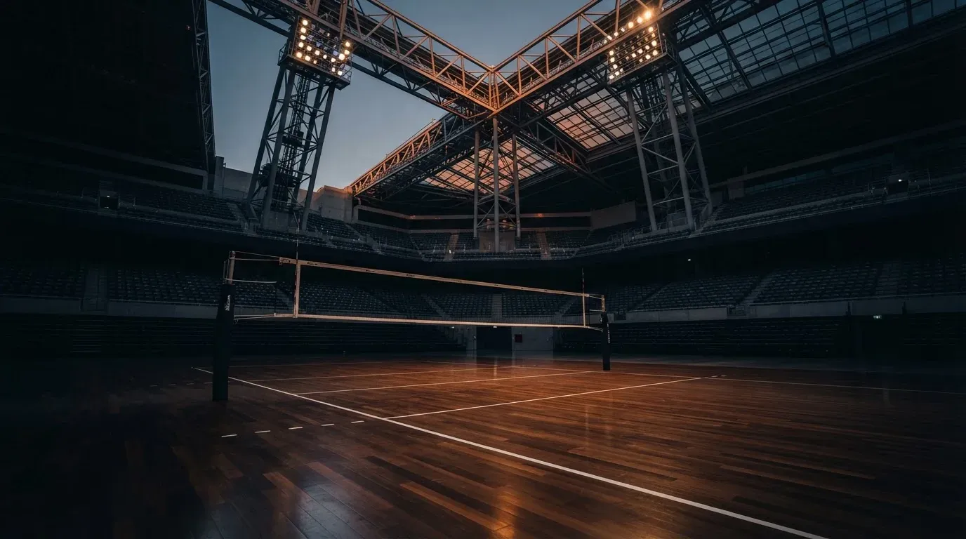 An empty football stadium with floodlight masts at dusk